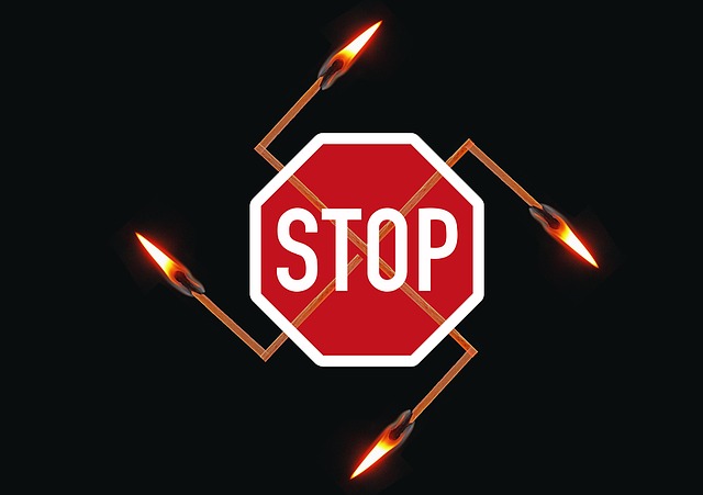 Streichhölzer als Hakenkreuz angeordnet, mit einem Stop-Schild darüber