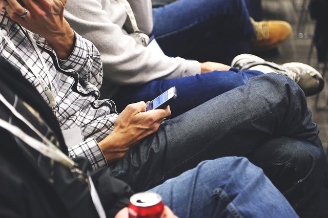 Mensch mit Handy im Wartezimmer beim Arzt